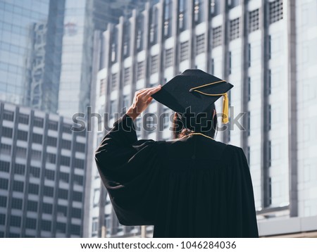 Graduation day, Back view of Asian woman with graduation cap and gown holding diploma, Successful concept Royalty-Free Stock Photo #1046284036
