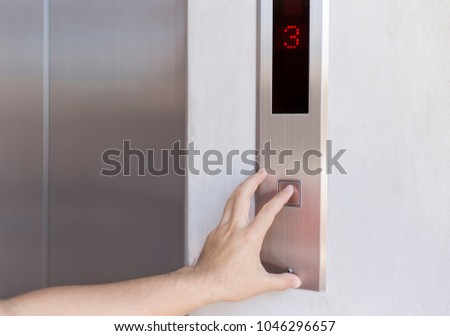 Man finger presses the elevator button, with Up and down Office building to floor 3.