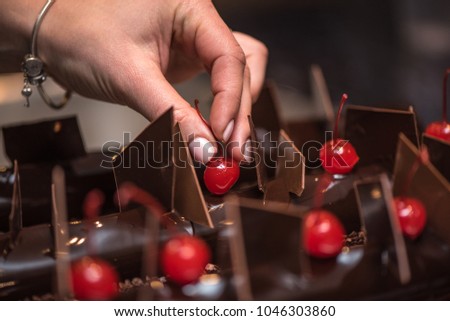Female hand decorating chocolate cake