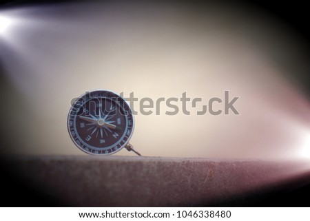 vintage compass on the ground with flare light from spotlight background.idea and concept 