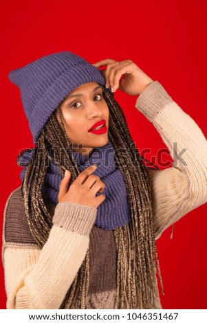 Young african woman beautiful woman with scarf  posing in the studio on a red background