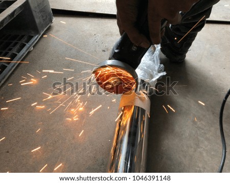 Closeup worker cutting steel
pipe with grinder 