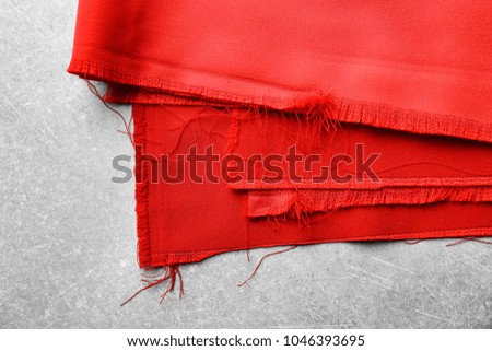 Red textile on grey background. Fabric texture
