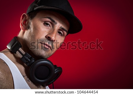 DJ with Scarfs and tatoo in front of a red background