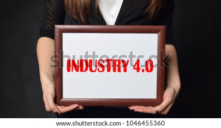 In the hands of a businessman a frame with the inscription:INDUSTRY 4.0