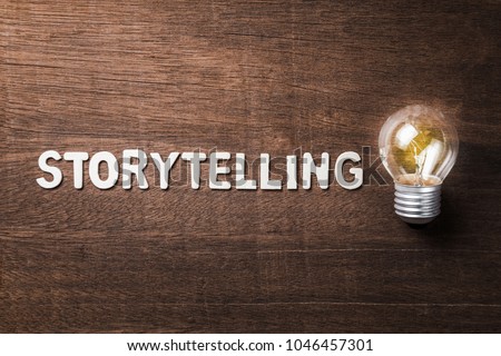 Storytelling word with glowing light bulb on wood texture