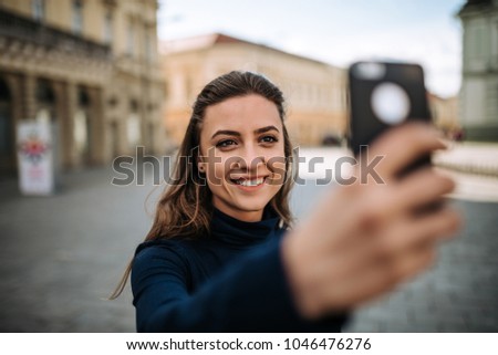 Young woman making a selfie at the city.
