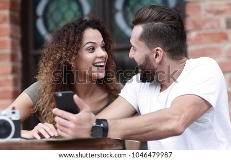 Portrait of a young  couple sitting down at a cafe terrace