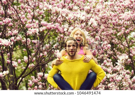 romantic couple in love in spring garden at beautiful blooming magnolia tree