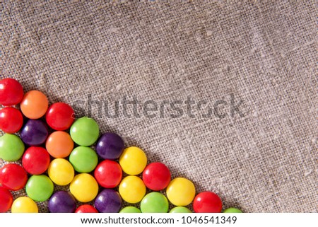 Chocolate candy in a colored glaze on a gray textural fabric