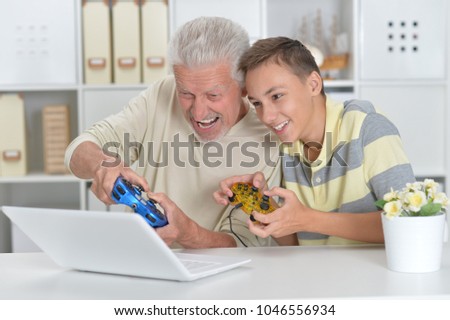  boy and  grandfather playing computer game