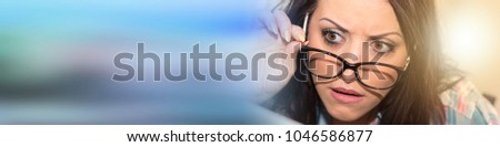 Young woman with astonished expression testing new glasses, light effect
