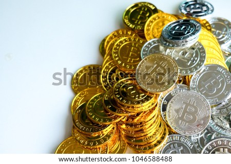 Among piles of golden and silver bitcoin on white background . Virtual cryptocurrency mining concept