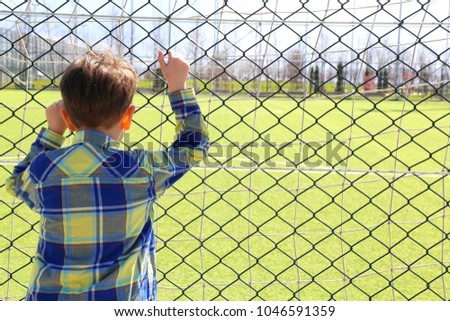 child in front of football field. 