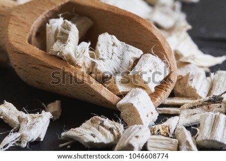 Dried and sliced marshmallow root (Althaea officinalis) in wooden scoop Royalty-Free Stock Photo #1046608774