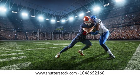 American football players preforms an action play in professional sport stadium Royalty-Free Stock Photo #1046652160