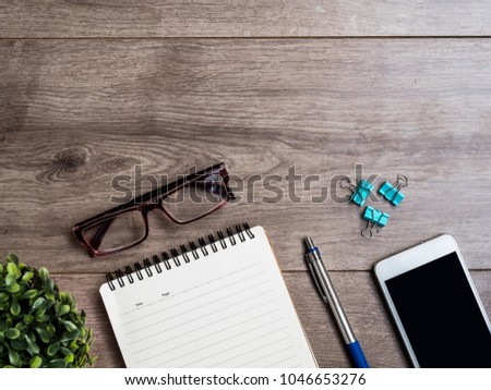 Office desk table with smartphone, pen , cup of coffee and eye glasses. Top view with copy space