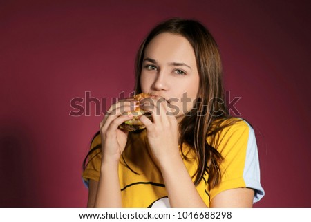 Woman eat burger sandwich with hungry mouth on pink background. Closeup composition of Fast food concept.