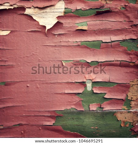 Pink paint on the green surface. Dry peeling paint on the wall. Text frame for text. Close up photo. Aged image. Abandoned place. Grunge background.
