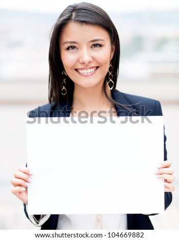 Happy businesswoman holding a white banner and smiling