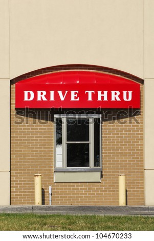 A window and drive thru sign on a brick building