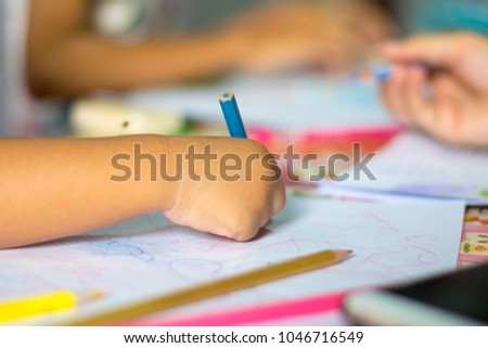 close up hand child drawing picture on the table