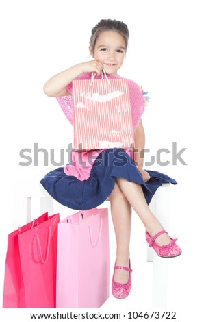Picture of beautiful little girl with pink shopping bags on white background