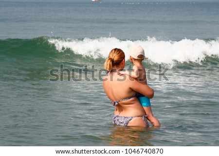 a mother and her child bathing in the sea