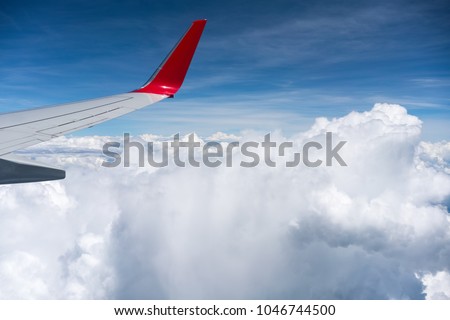 airplane airfoil above the clouds, airline traveling Royalty-Free Stock Photo #1046744500