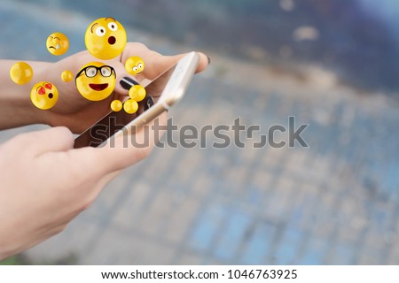 Close-up of woman using smartphone sending emojis. Social concept. Royalty-Free Stock Photo #1046763925