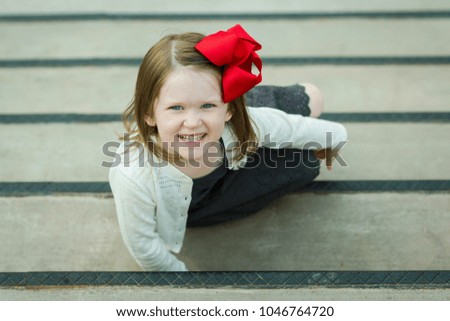 Happy Little Girl with Red Bow and Grey Dress