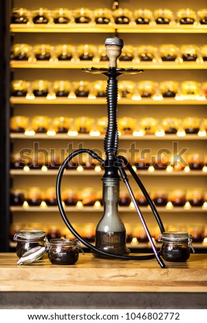 Hookah on water stands on the bar with banks of tobacco with different tastes. Shisha Concept