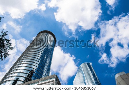 Blue sky and partly clouds with Modern silver glass circular highrise skyscraper rising up from the downtown cityscape skyline of Houston , Texas ,USA