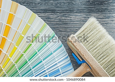 Horizontal view of color palette fan paintbrush on wooden board