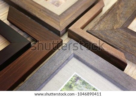 A collection of solid wood photo picture frame corner samples are displayed on a table.