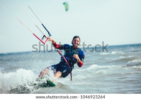 Kitesurfing Kiteboarding action photos man among waves quickly goes Royalty-Free Stock Photo #1046923264