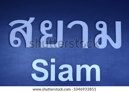 Thai BTS skytrain station sign SIAM written in white on blue backgorund in latin and thai alphabet