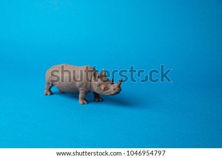 toy rhinoceros on blue background
