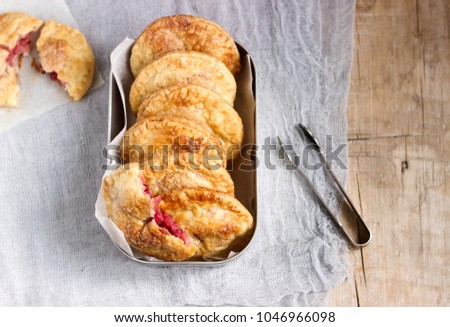 Crispy mini pies with apple and red currant. Rustic style, selective focus.