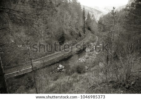Old narrow railway in Pirin Mountains. Dramatic scenic scene. railway in autumn Mountain landscape. Cloudy clouds over mountains. Concept of travel in poor countries. Retro style