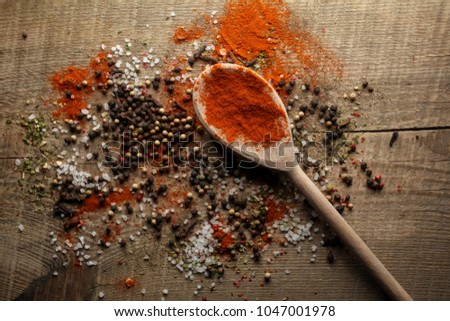 Black and white pepper peas, sea salt, red pepper powder, cloves, spices in a spoon on a wooden background. Various colorful spices close up background. photo for the menu. Selective focus