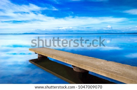 Pier or jetty, sunset blue panoramic landscape. Orbetello lagoon with reflection, Argentario, Tuscany, Italy.