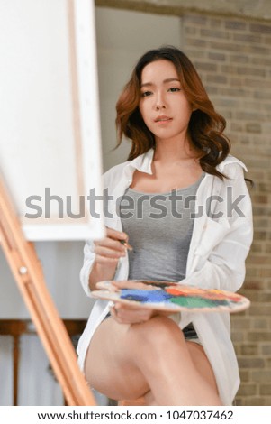 Concept Artist Beautiful girl. Beautiful women are creating art. Beautiful woman is painting happily. Young artist painting in the gallery.
