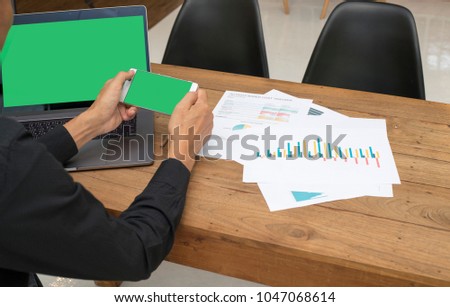 A business man using mobile phone for work with green screen