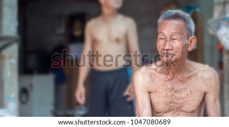 Old man does not wear a shirt, look at something.
