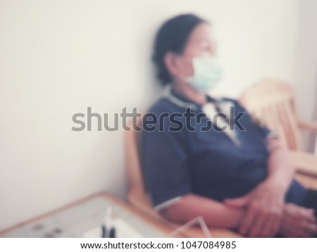 Blurry image, woman sleeping in a sitting position on a chair alone. And a masked white color the face. , Health symbols and hidden, escape,need blur picture