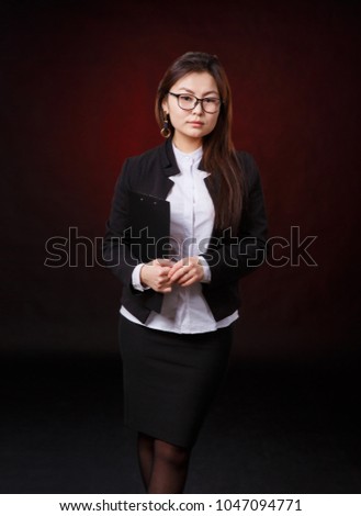 Young engineer with folder on black and red background.Asian businesswoman on a black background
