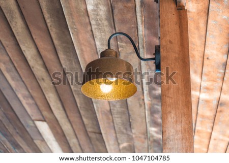 The vintage lamp is attached to the wooden pole.