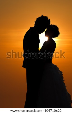 Sunset silhouette a young couple embracing