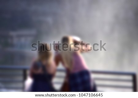 Selective focus image of two girl in the waterfalls landscape travel theme creative abstract blur background with bokeh effect. Suitable for designs as background